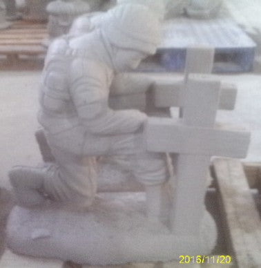 SOLDIER KNEELING BY CROSS